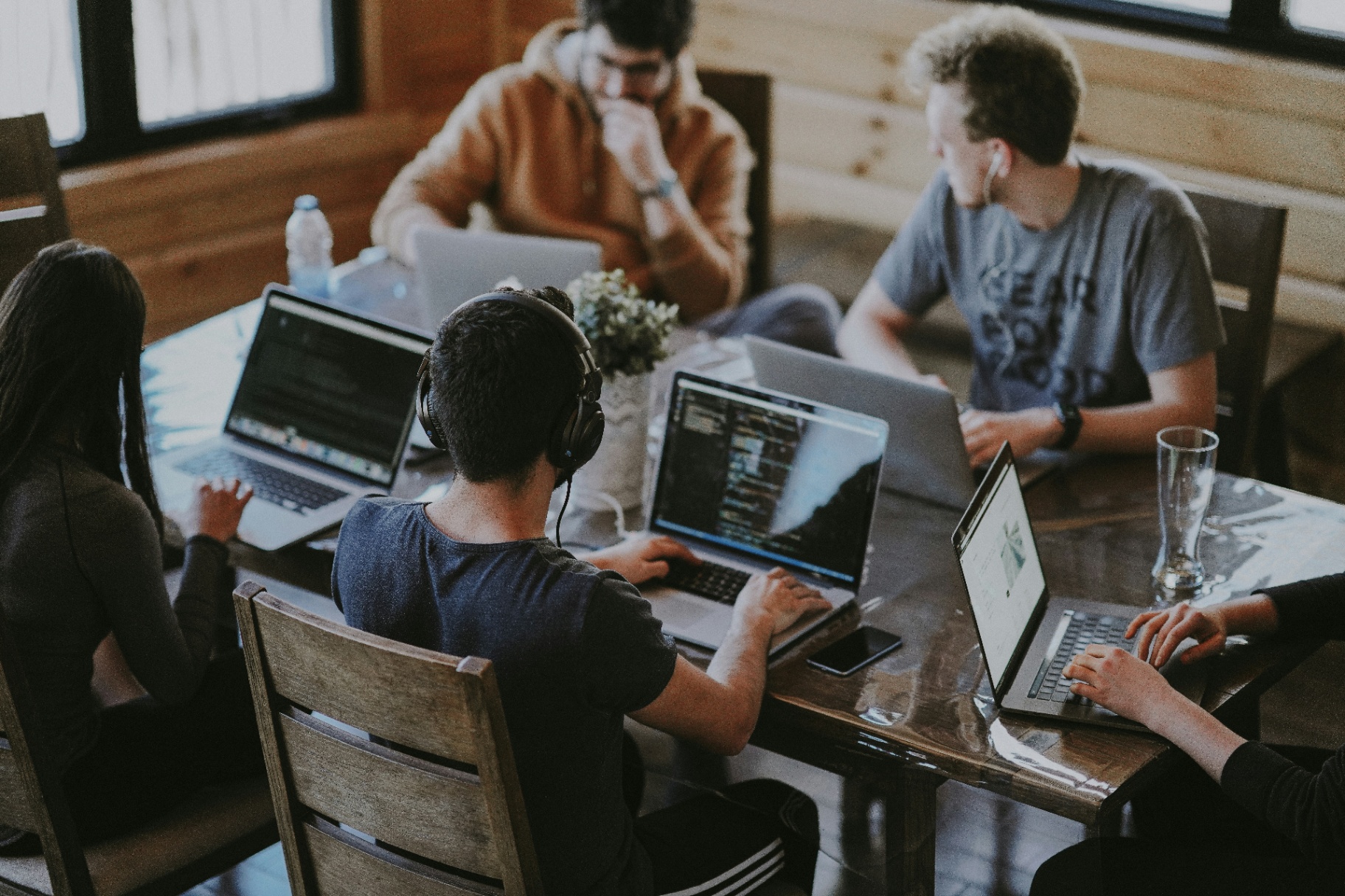 Overhead view of a diverse team working together on laptops