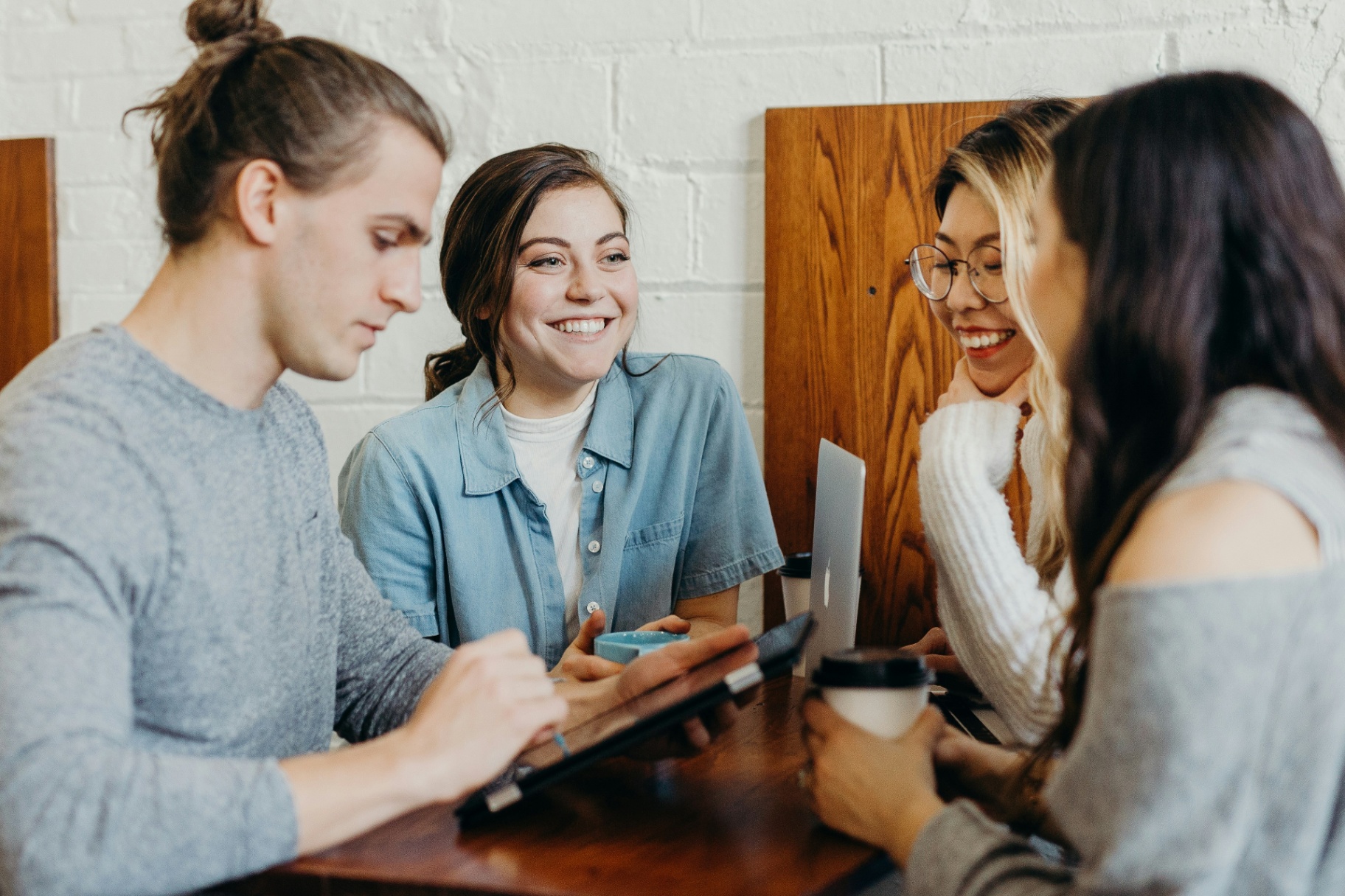 Diverse coworkers smiling and chatting around a cafe table